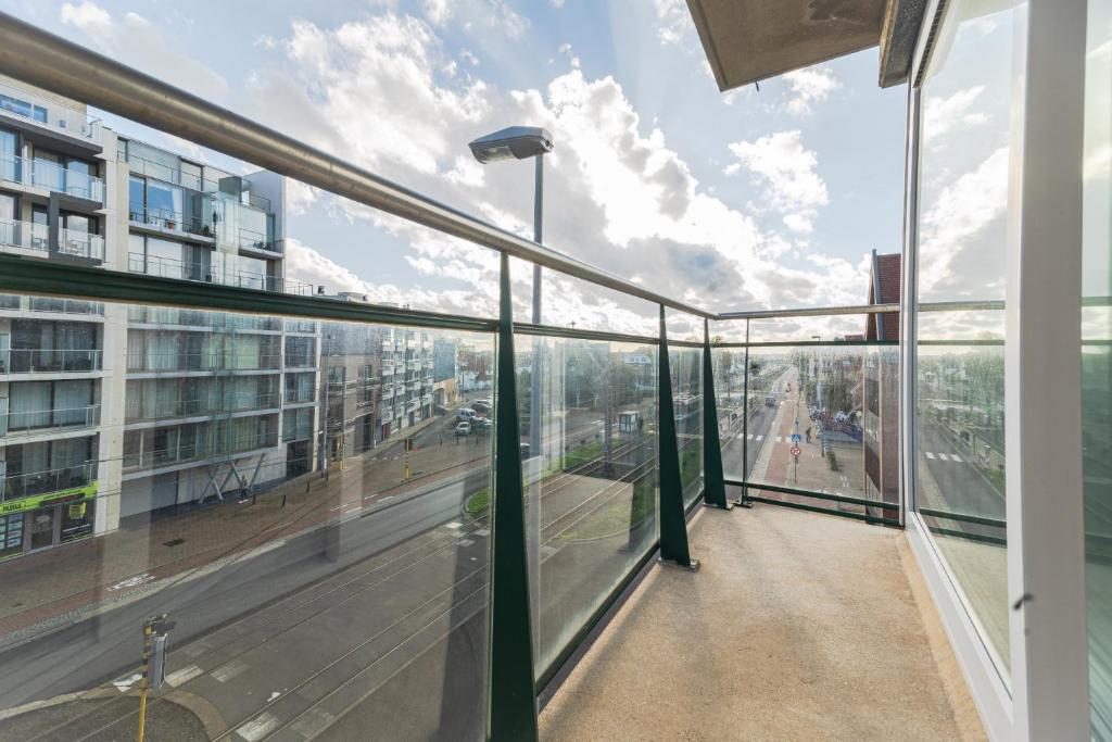 Elle comprend un balcon offrant une vue sur une rue de la ville. dans l'établissement Euro IV 0306, à Middelkerke
