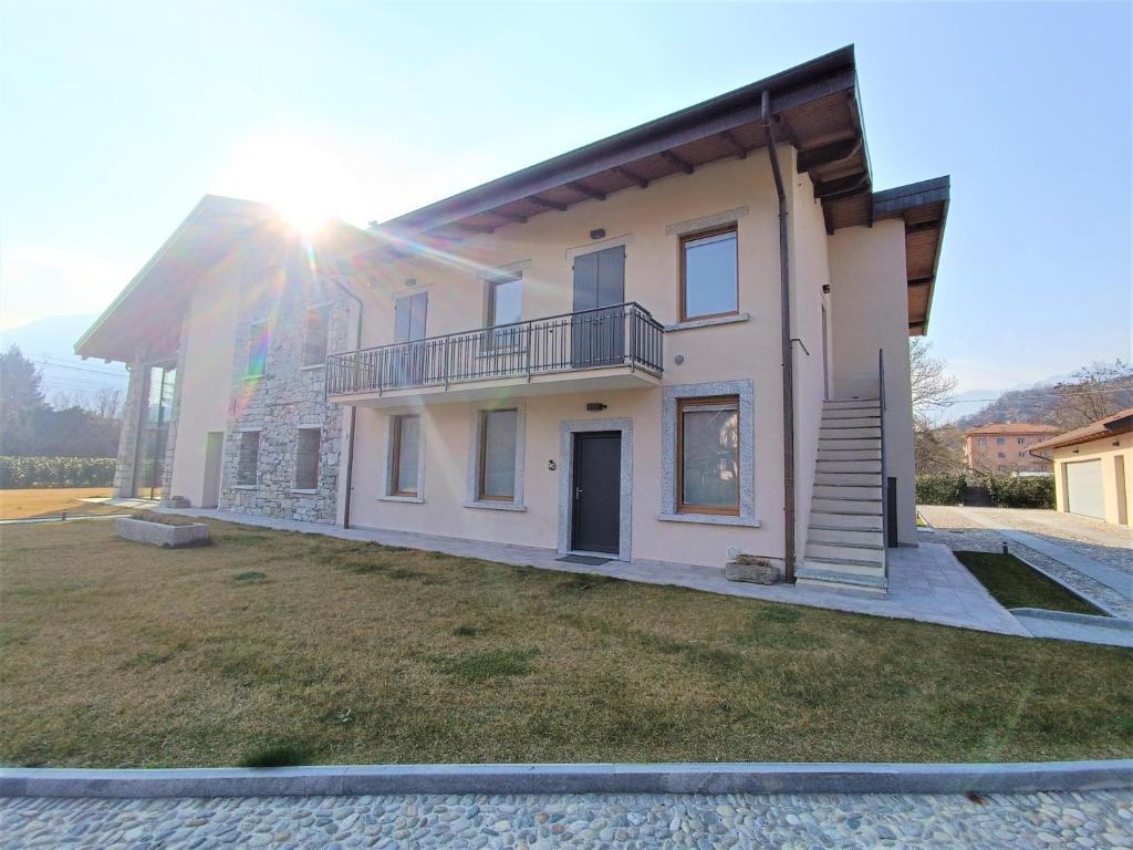 a large house with the sun shining on it at Winter Spring Summer Apartments in Mergozzo