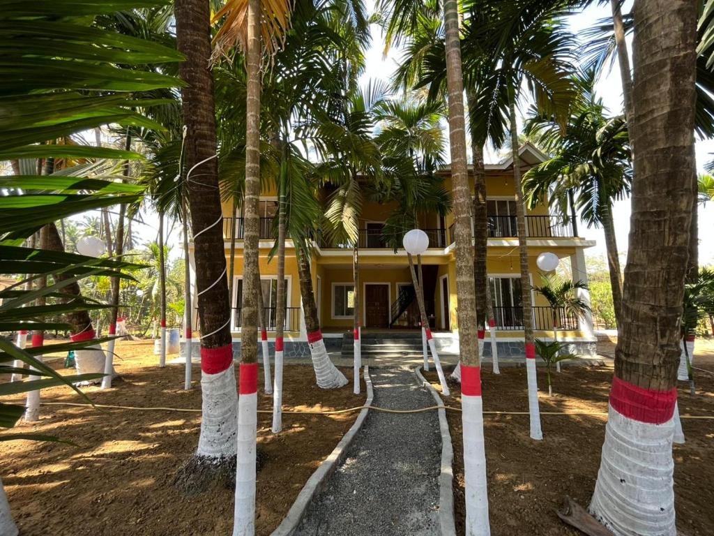 una casa con palme di fronte di Riva Gold By Flora Stays ad Alibaug