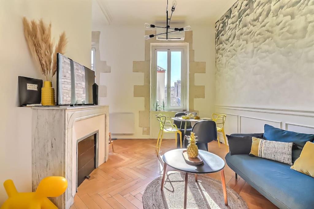 salon z niebieską kanapą i kominkiem w obiekcie Le Yellow - Central - Climatisé w mieście Nîmes