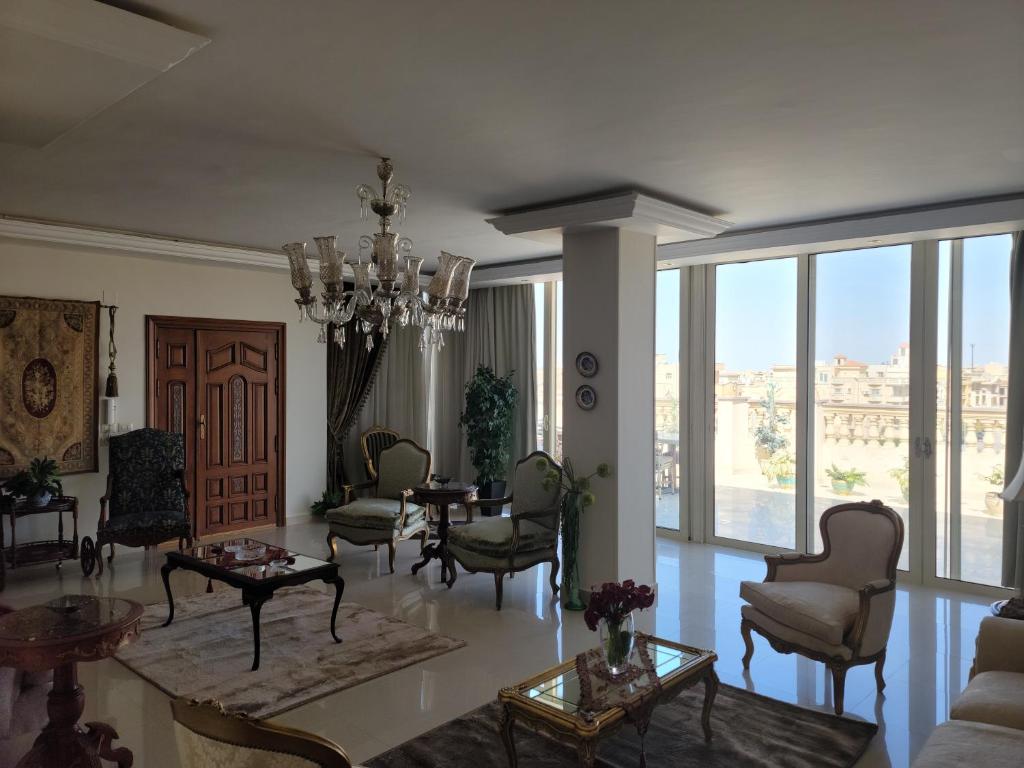 a living room with chairs and a chandelier at Rooftop Apartment with Terrace in Cairo