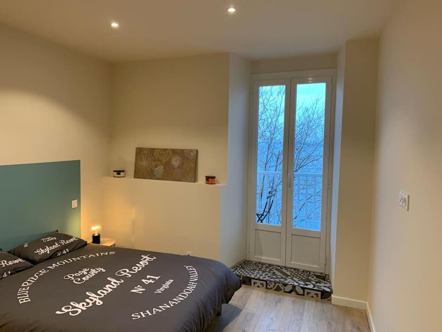 sypialnia z łóżkiem i dużym oknem w obiekcie Appartement rénové vue mer - citadelle de Bastia w Bastii