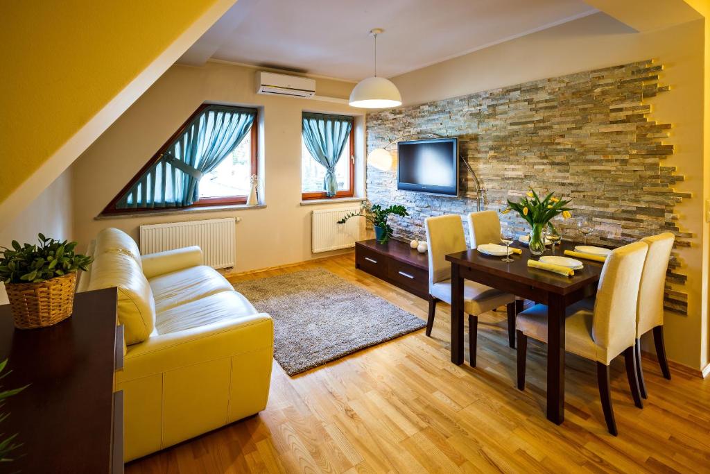 a living room with a yellow couch and a table at Zakopane Apartamenty LUX in Zakopane
