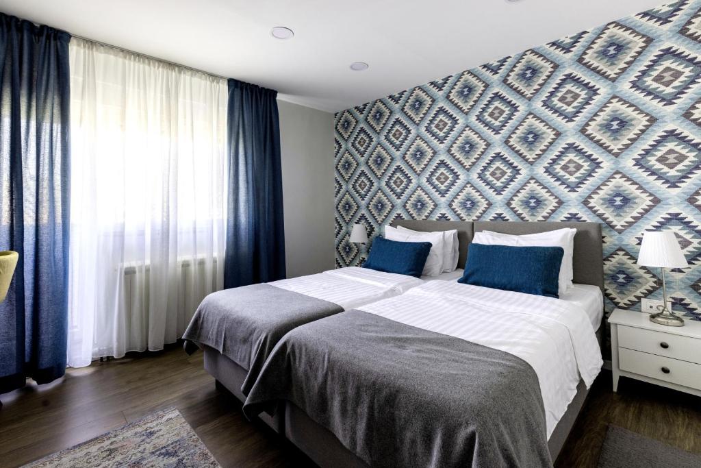een slaapkamer met een groot bed met een blauwe muur bij Apartment Sovre in Belgrado