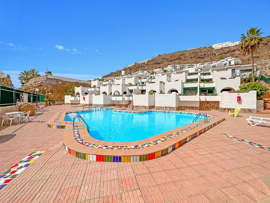 una gran piscina frente a un edificio en Apartamentos Laguna, en Puerto Rico de Gran Canaria