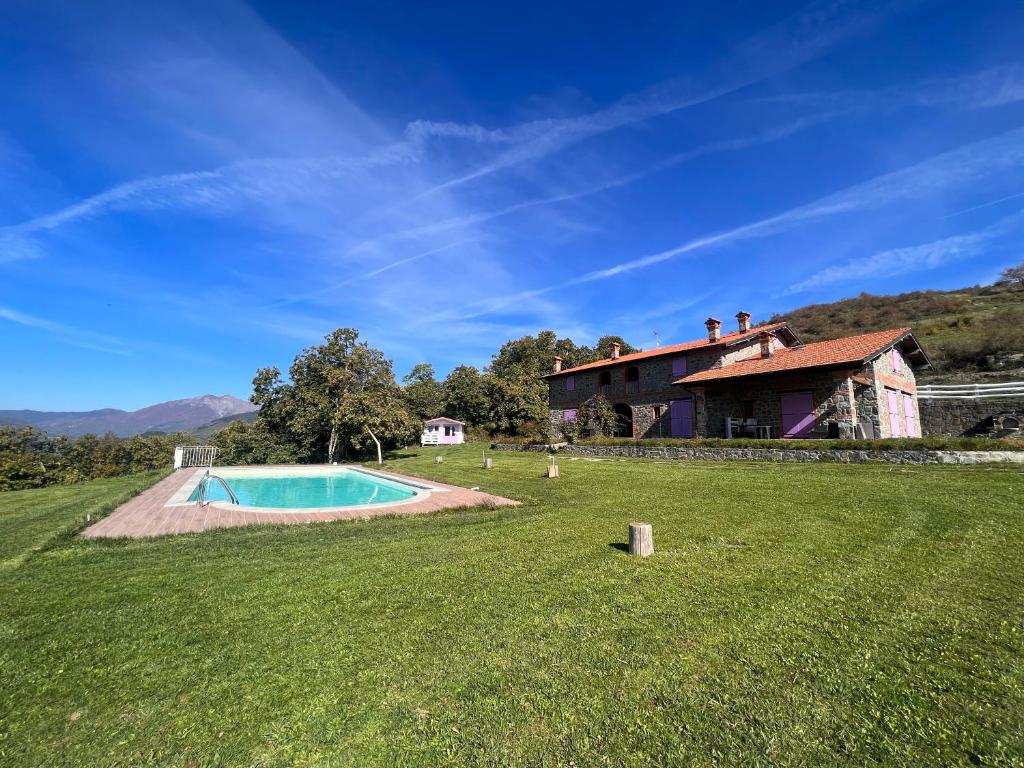 a large yard with a swimming pool in front of a house at Agriturismo Il Serrino in San Marcello Pistoiese