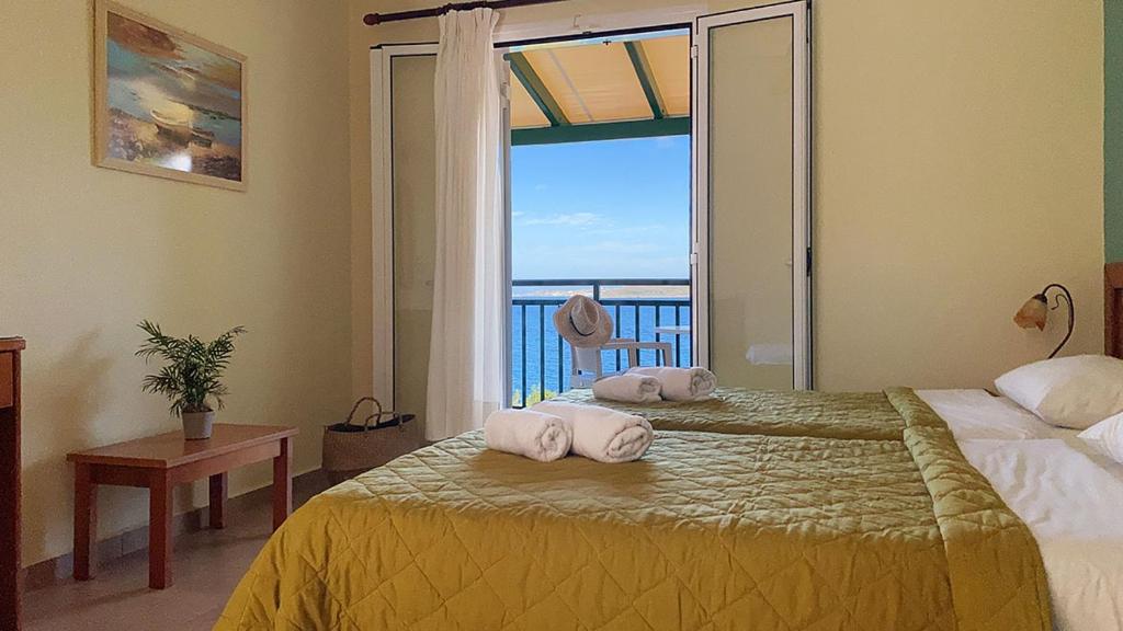 a bedroom with two towels on a bed with a window at THEKLI STUDIOS in Argostoli