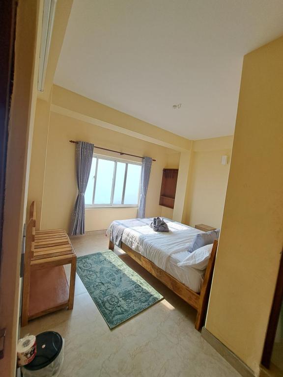 una camera da letto con un letto e una finestra di Himalayan Hidden Treasure a Pokhara