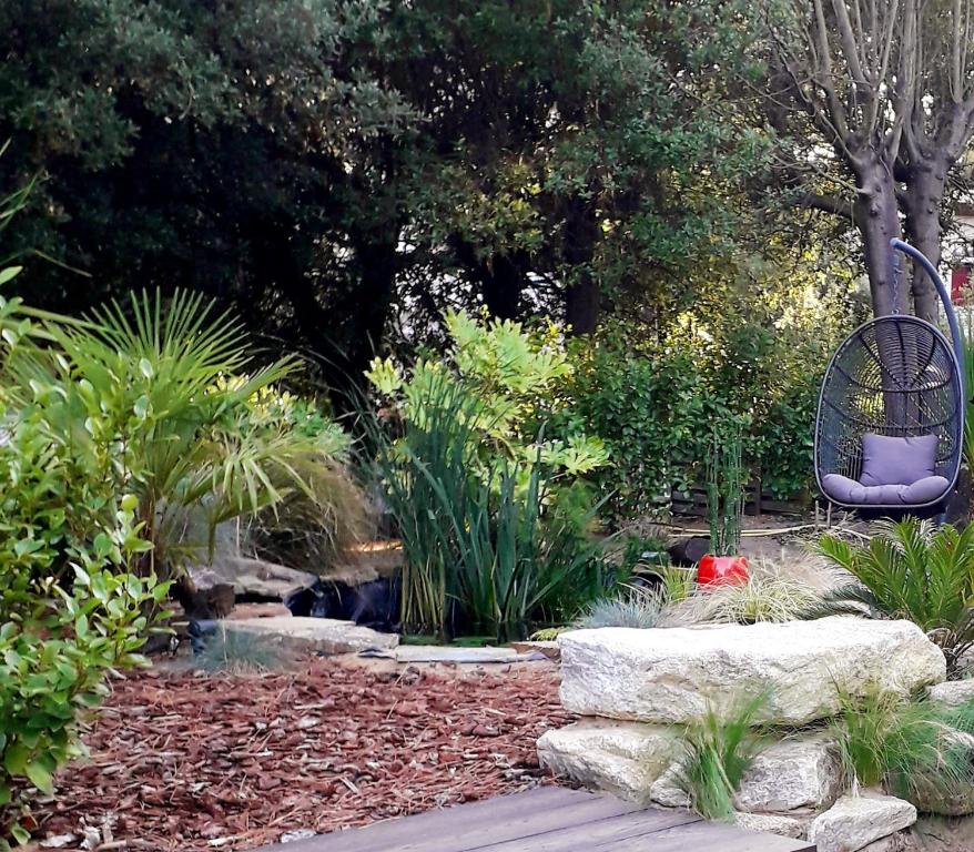 a garden with a bench and a pond and trees at Belle de Dune in La Baule