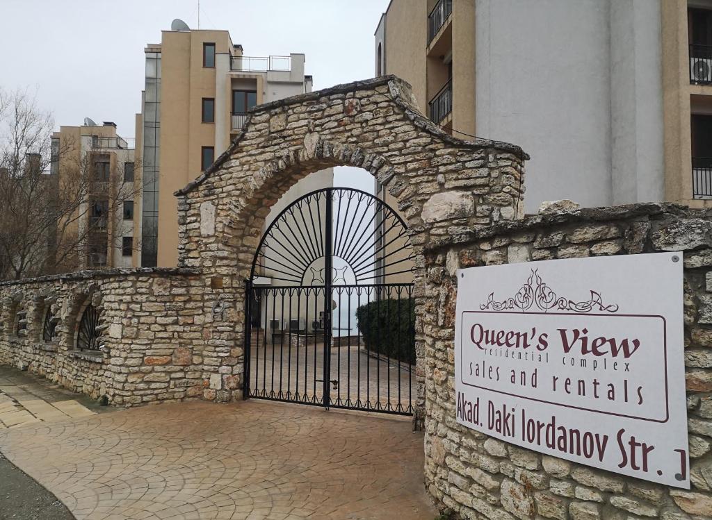 una puerta de piedra con una señal frente a un edificio en QUEEN'S VIEW app-9 free pool,parking, fitness & sea view en Balchik