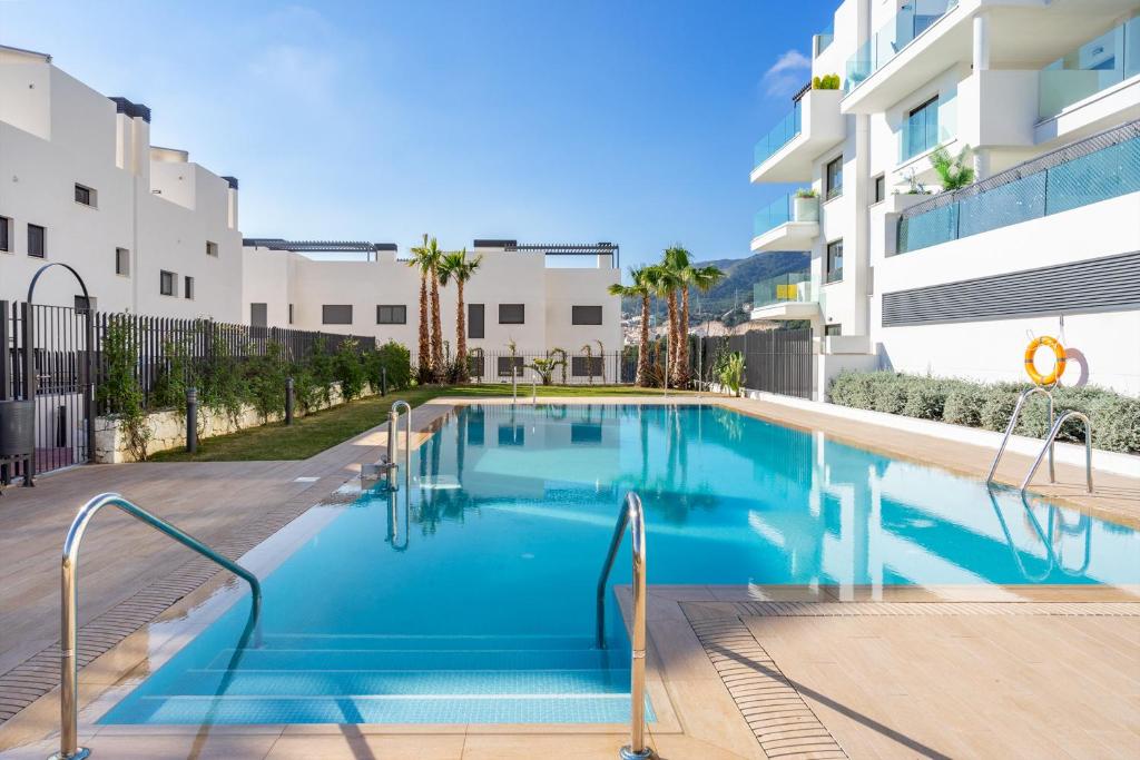 a swimming pool in front of a building at Modern apartment with pool in Benalmadena Ref 47 in Benalmádena