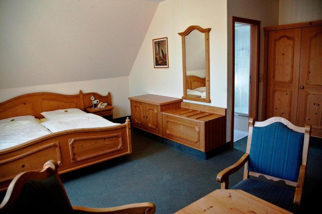 een slaapkamer met een bed, een dressoir en een spiegel bij Gasthof zur Schwane in Abtswind