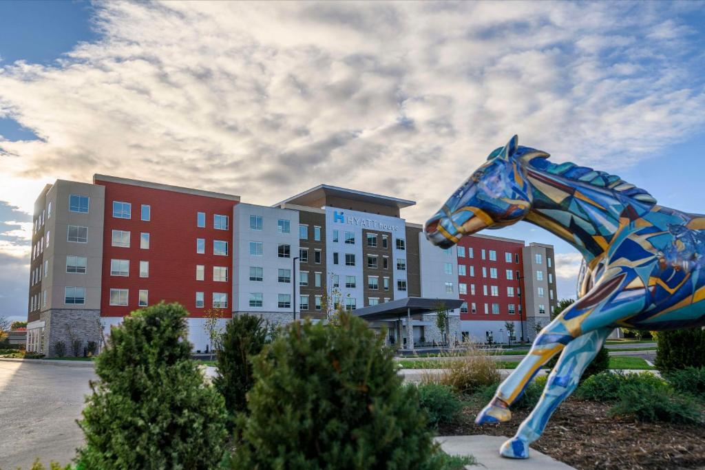 uma estátua de um cavalo em frente a um edifício em Hyatt House Louisville East em Louisville