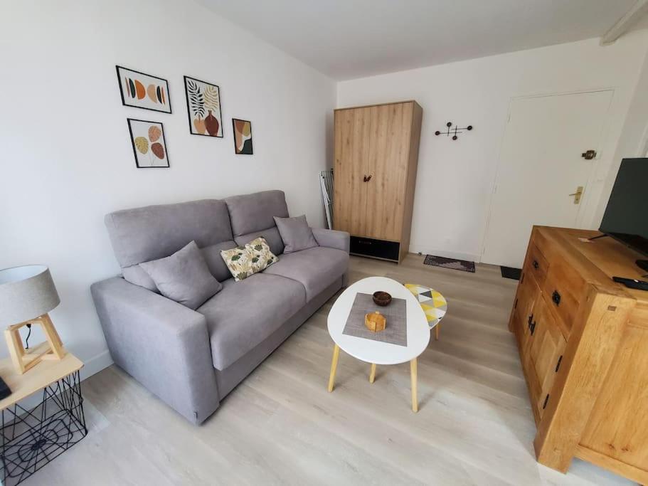 sala de estar con sofá y mesa en Appartement cosy climatisé à Sarlat, en Sarlat-la-Canéda