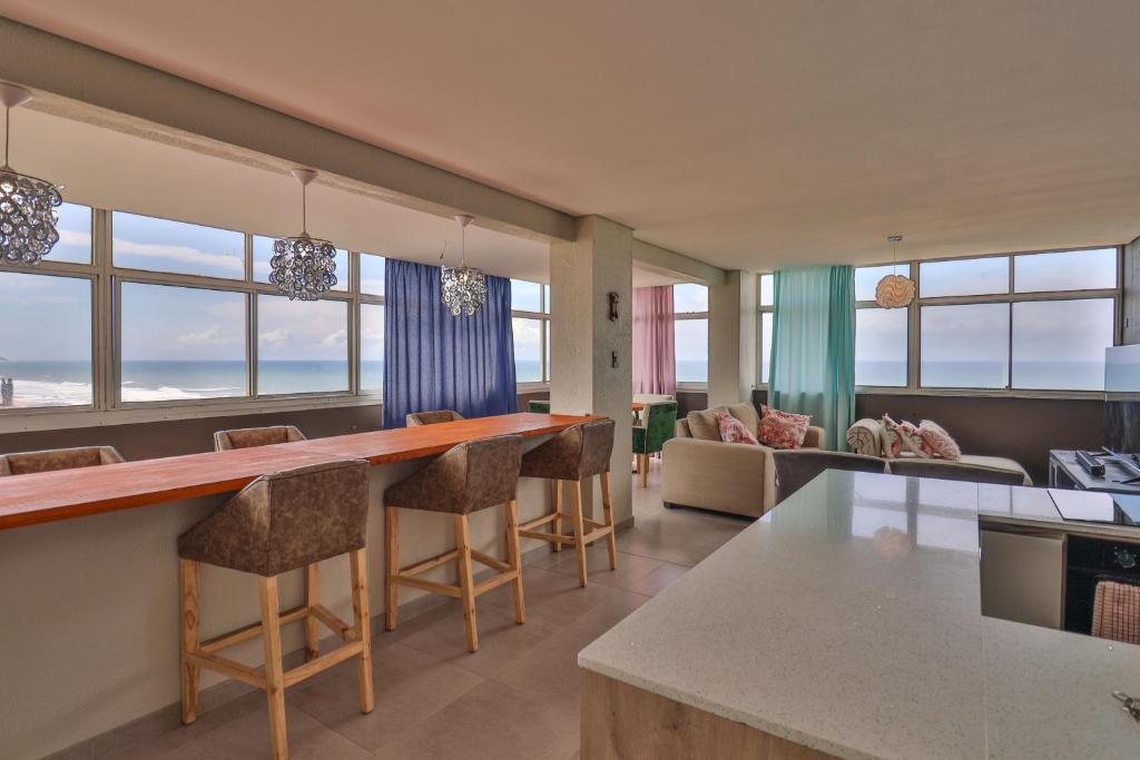 a kitchen and living room with a view of the ocean at Shangri-La Self Catering Holiday Apartment in Kingsburgh