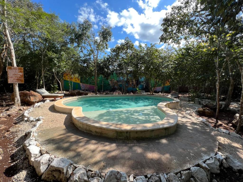 uma piscina com uma fonte num jardim em Hotel B. Secreto Maya em Yaxché