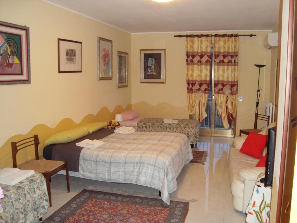 a bedroom with two beds and a couch at B&B Casa Ferrara in Monopoli