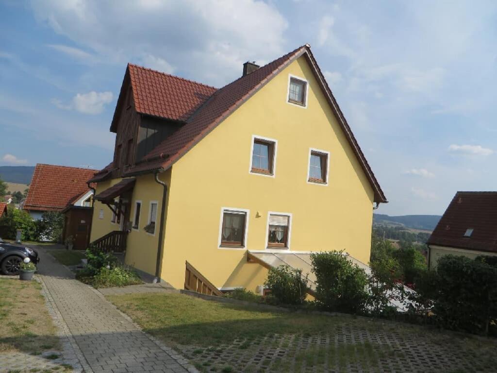 ein gelbes Haus mit braunem Dach in der Unterkunft Pension-Gästehaus Küblböck in Neualbenreuth