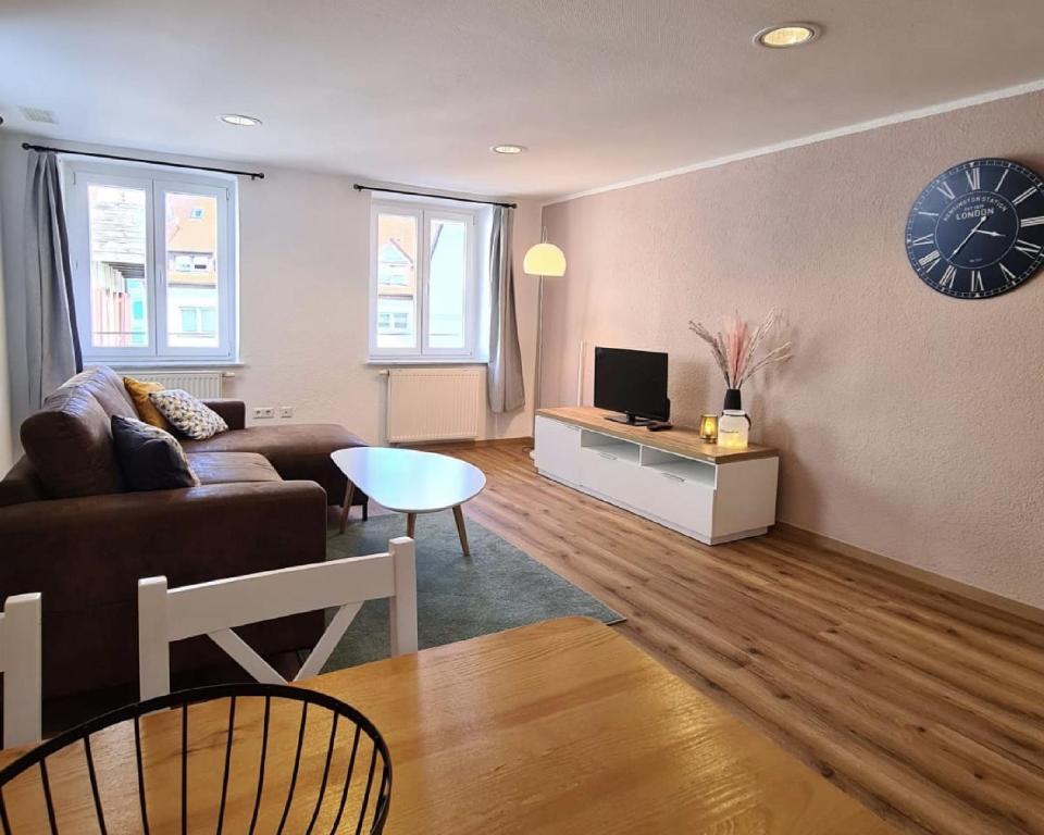 a living room with a couch and a clock on the wall at Stadtzimmer im Entenmoos in Bad Waldsee