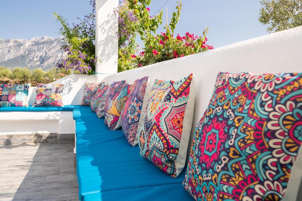 una fila de almohadas coloridas en una pared en Villa s'ena e su juncu, en Loculi