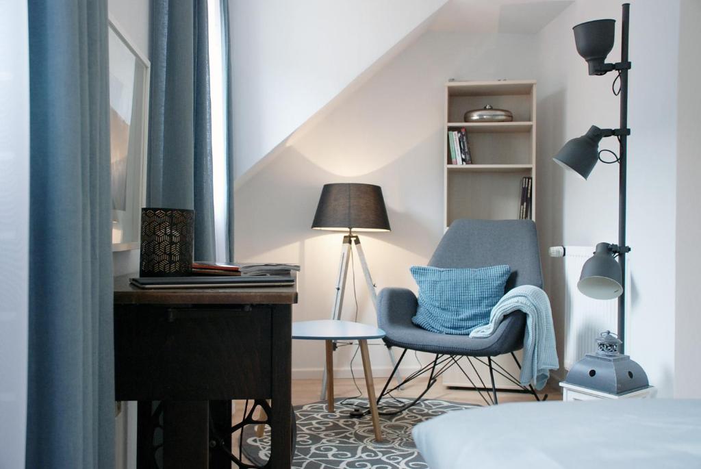 ein Schlafzimmer mit einem Stuhl, einem Schreibtisch und einer Lampe in der Unterkunft LUX Ferienwohnung im Weinort Pommern an der Mosel in Pommern