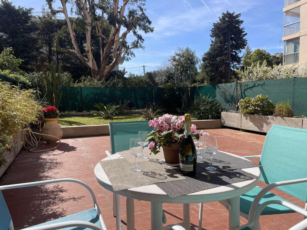 a table with a bottle of wine and flowers on a patio at Appartement Antibes, 2 pièces, 4 personnes - FR-1-252-126 in Antibes