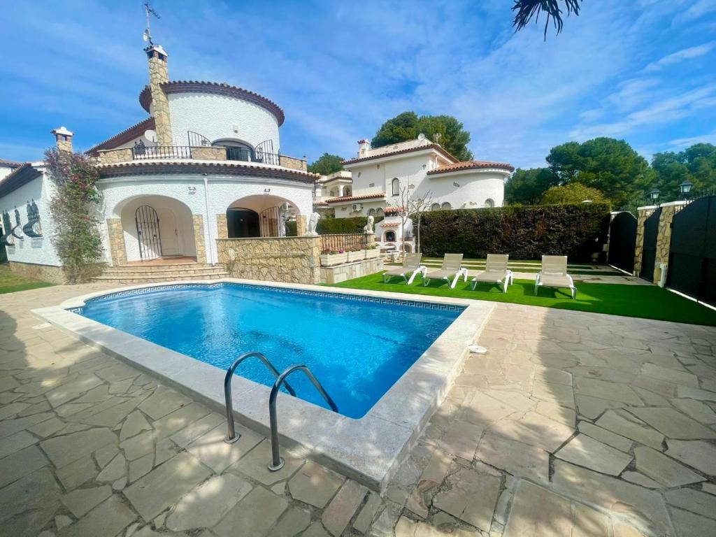 a swimming pool in front of a house at Pino Alto Villa Jazmin in Miami Platja