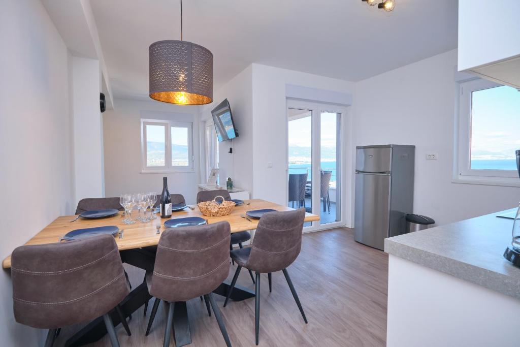 uma cozinha e sala de jantar com mesa e cadeiras em Queen's Lodge Mastrinka em Trogir