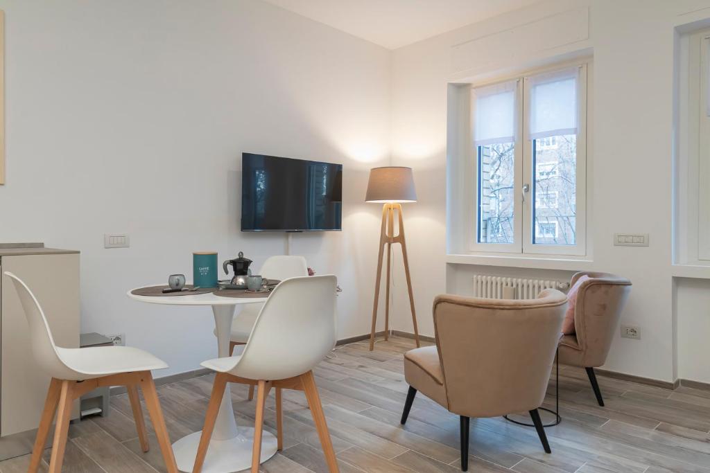 a living room with a table and chairs at Suite Campania - ristrutturato nuovo vicino M4 in Milan