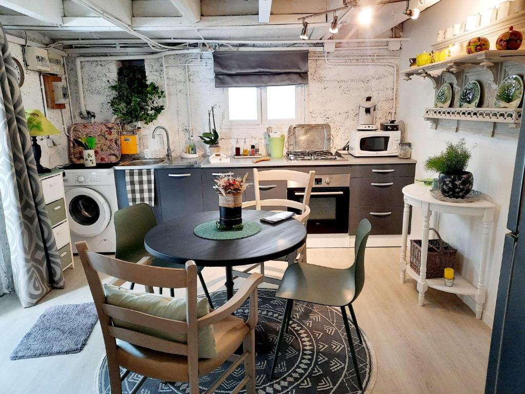 een kleine keuken met een tafel en stoelen. bij Le Petit Nicol in Bergerac