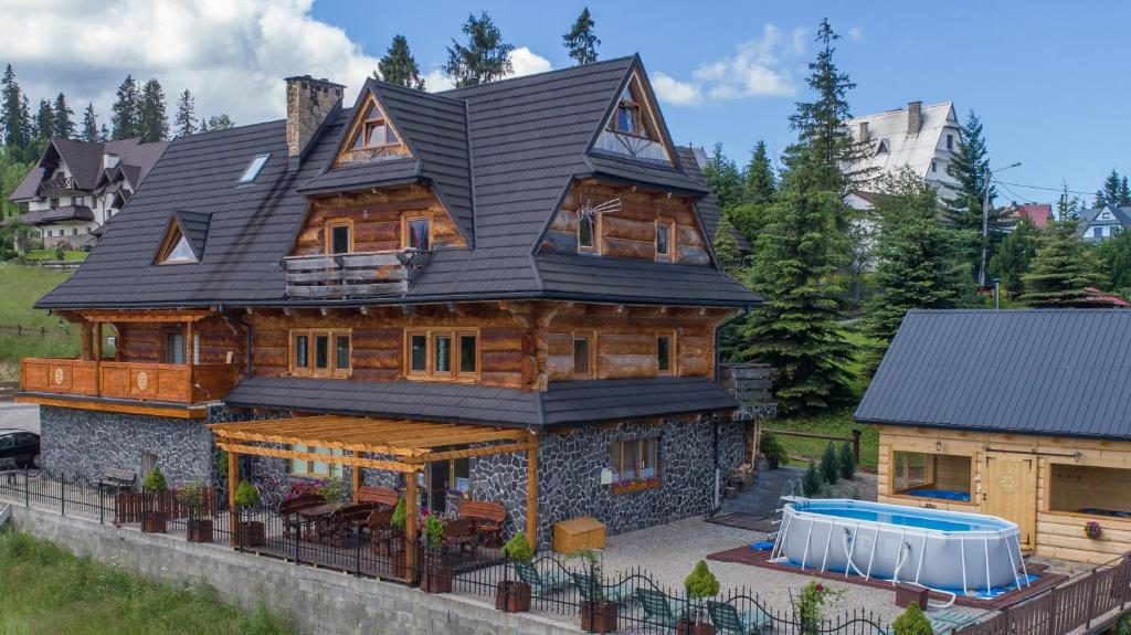 a large wooden house with a black roof at Bukowiańska Ostoja Jacuzzi Sauna i Balia w Ofercie, 60m od Wyciągów in Bukowina Tatrzańska