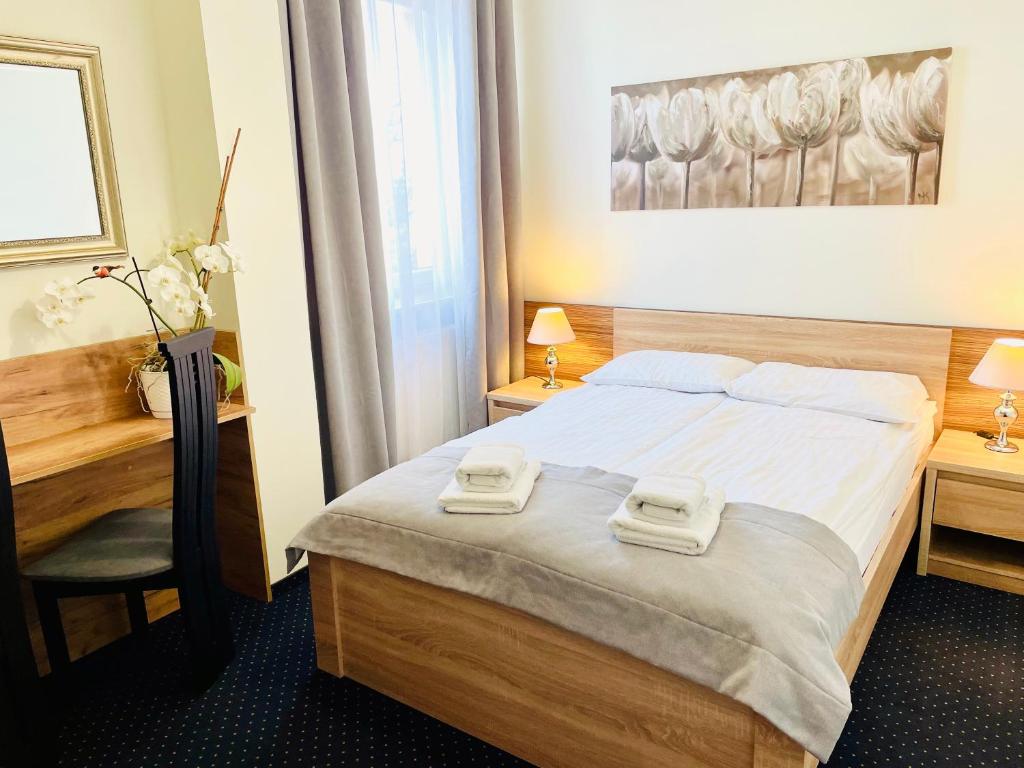 Una habitación de hotel con una cama con dos toallas. en Hotel Seven 7, en Kalisz