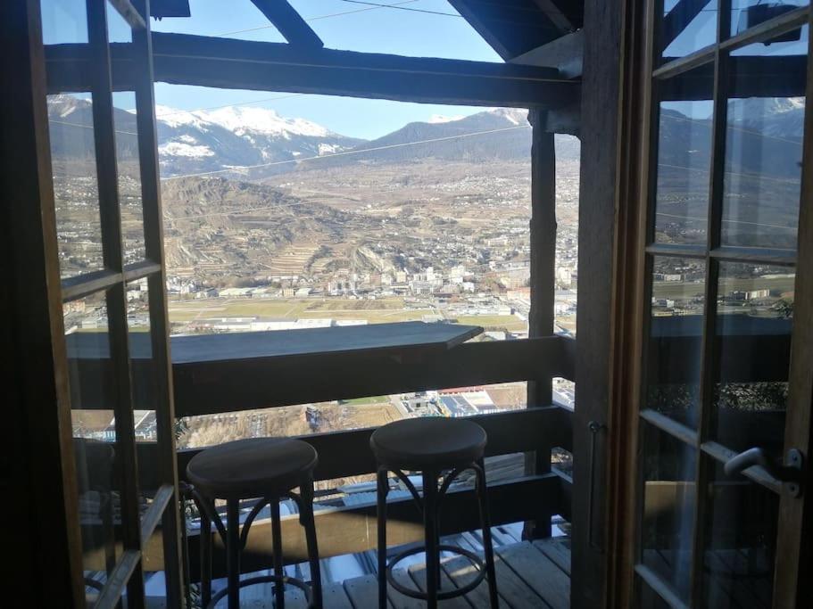 a view of a mountain from a balcony with two stools at Le Raccard de Turin VS in Salins