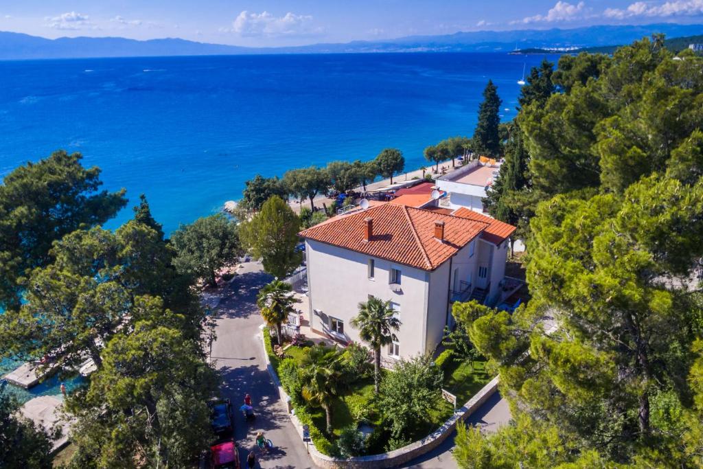 Vue aérienne d'une maison avec l'océan en arrière-plan dans l'établissement Apartments & Rooms Milcetic D, à Malinska