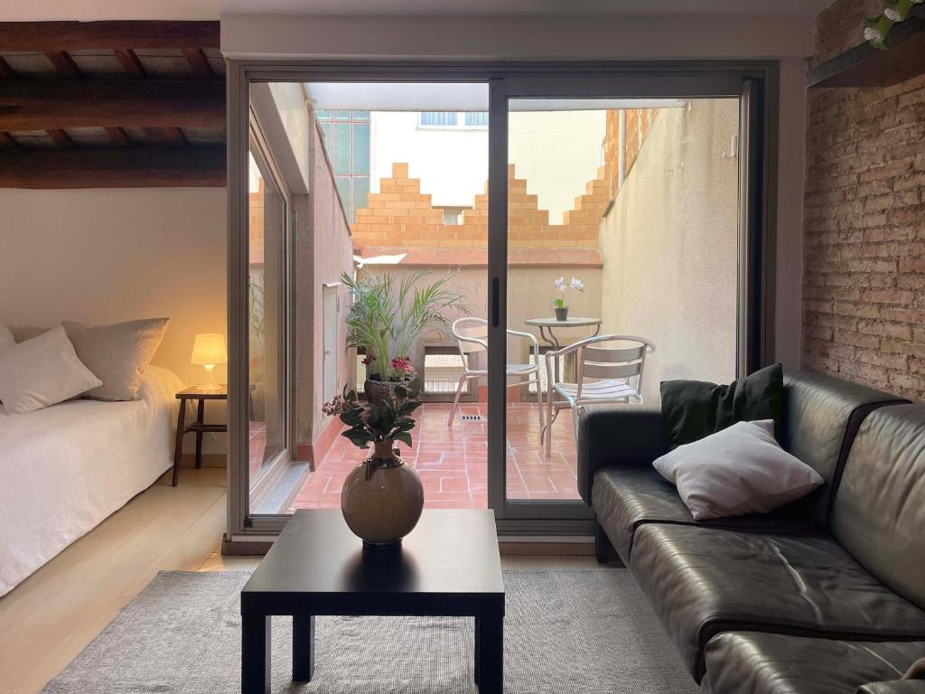 - un salon avec un canapé et une table dans l'établissement SF Apartamento céntrico con terraza, à Terrassa