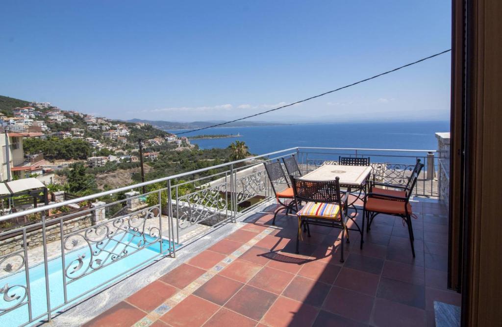 a balcony with a table and chairs and the ocean at Malvazios Villas Panorama Pool Villa in Gythio