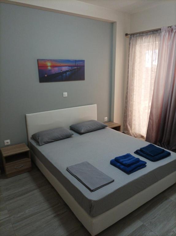 a bedroom with a bed with blue towels on it at Alimos Apartments in Athens