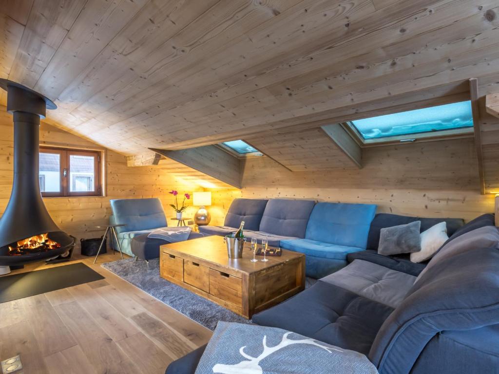 a living room with a blue couch and a fireplace at Chalet La Clusaz, 8 pièces, 13 personnes - FR-1-304-177 in La Clusaz