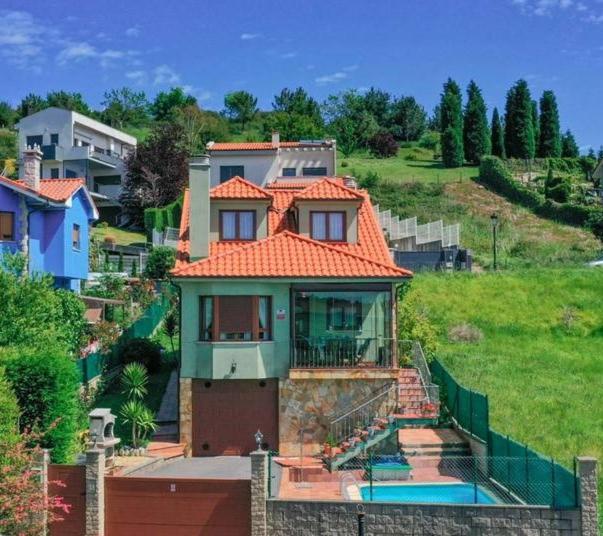 une maison avec un toit orange sur une colline dans l'établissement Casa Villa Mey, à Candás