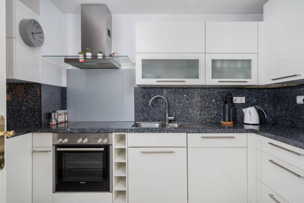 Biała kuchnia z białymi szafkami i zlewem w obiekcie El Porton bright apartment in Calahonda by Costarentals - Ref 95 w mieście Sitio de Calahonda