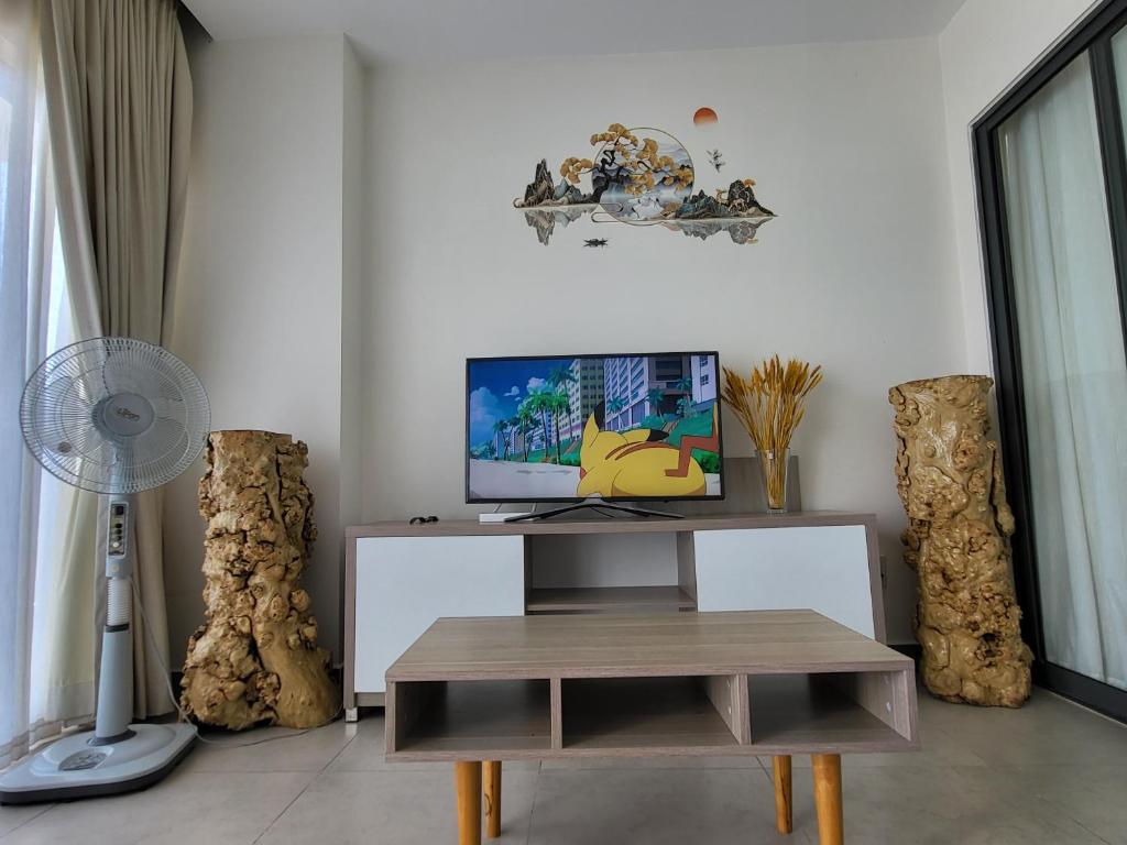 Căn hộ Aria Resort Vũng Tàu 3 Phòng ngủ في Xã Thắng Nhứt: غرفة معيشة مع مكتب مع تلفزيون وطاولة
