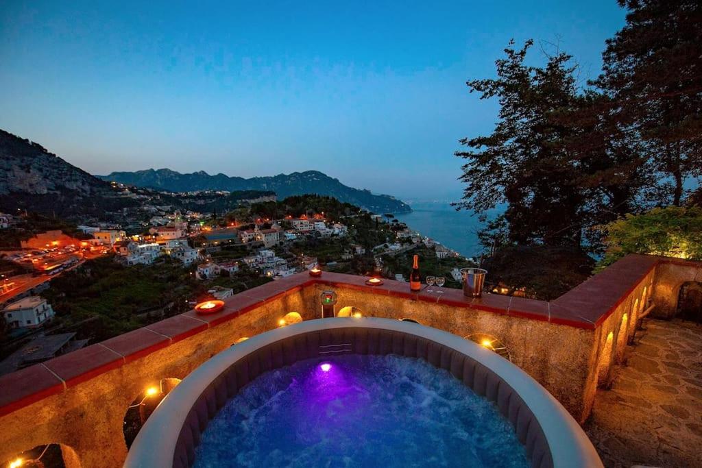 a bath tub with a view of a city at night at Villa Nina Amalfi in Amalfi