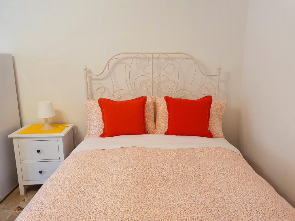 Un dormitorio con una cama con almohadas rojas. en Fiori e Frutti - Appartamento Economy, en Almese