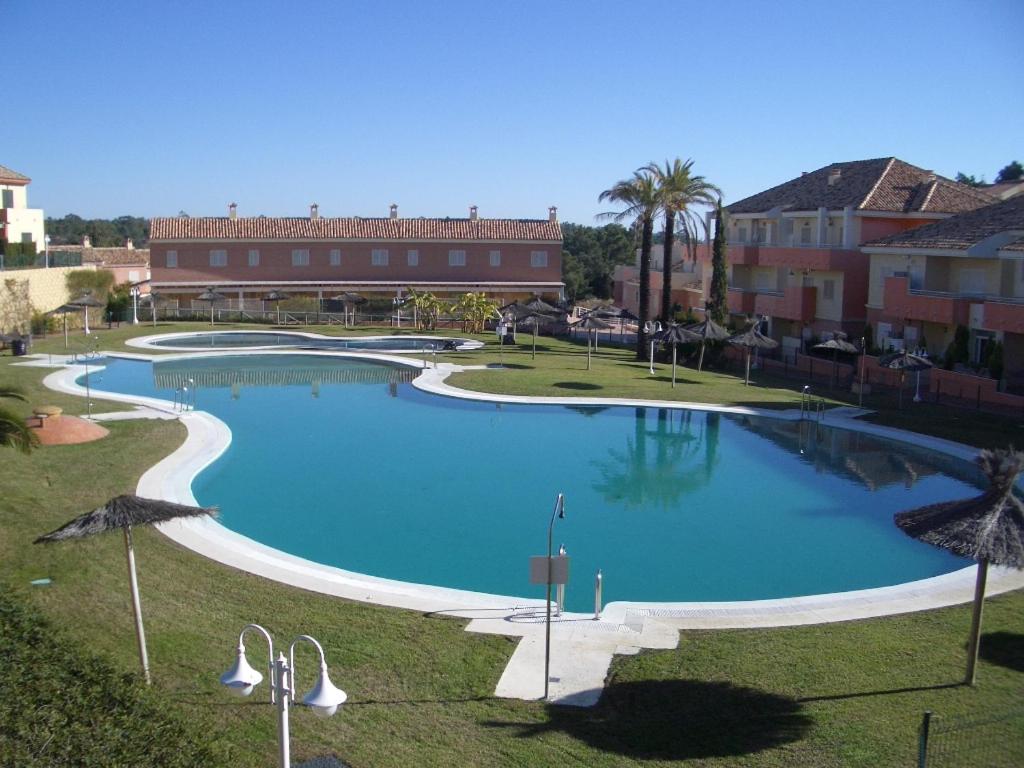 uma grande piscina em frente a um edifício em ADOSADO FAMILIAR em Huelva