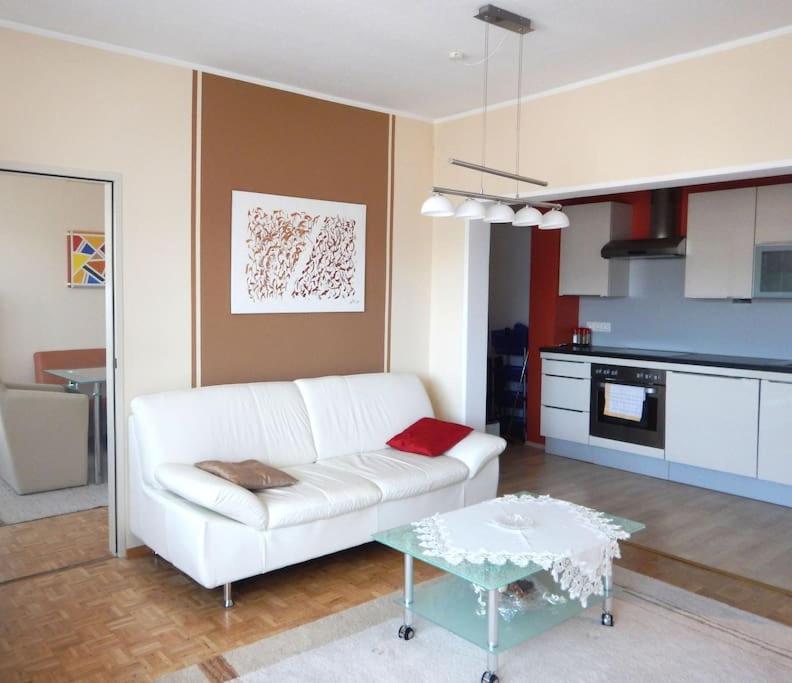ein Wohnzimmer mit einem weißen Sofa und einem Tisch in der Unterkunft Penthouse near Red Bull Ring in Knittelfeld