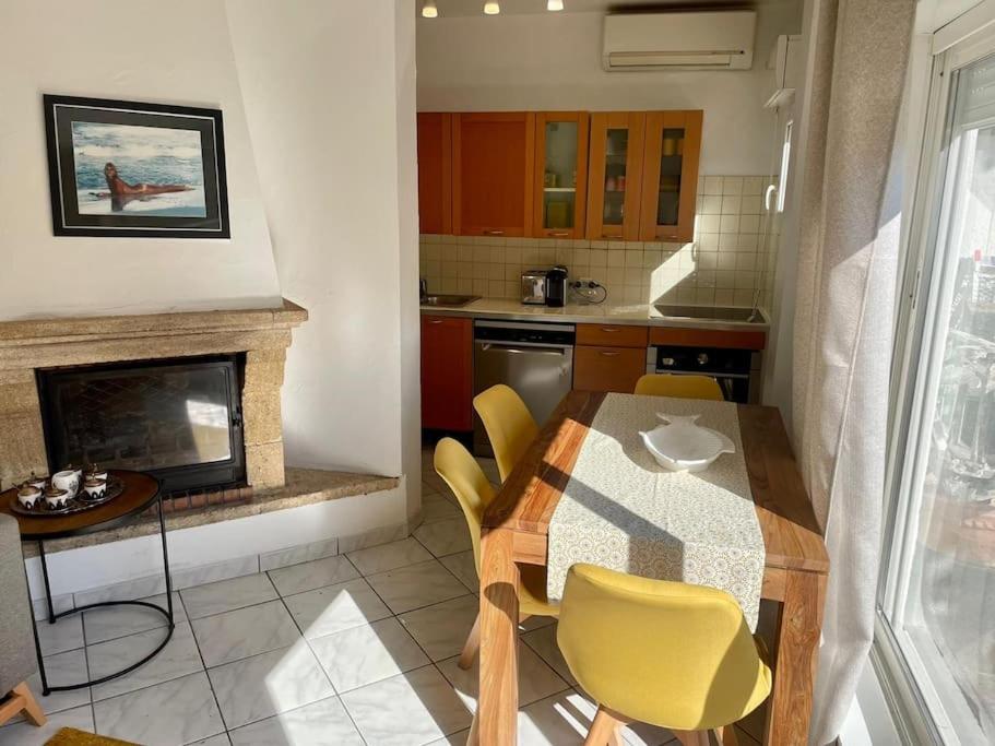 une cuisine avec une table à manger et une cheminée dans l'établissement Super appartement avec terrasse, centre ville, à Saint-Tropez