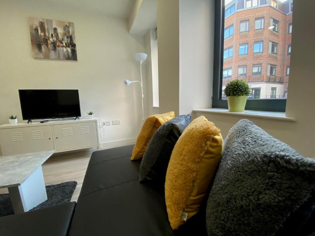 a living room with a couch and a tv at Snapos Apartments - Platform A in Bedford