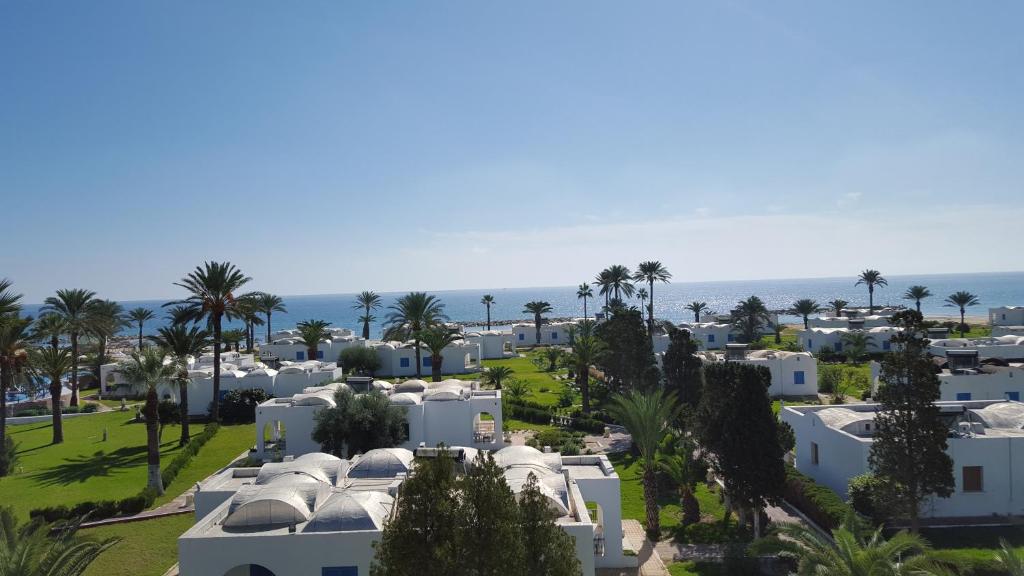 - une vue aérienne sur les maisons blanches et les palmiers dans l'établissement Royal Lido Resort & Spa, à El Fehri