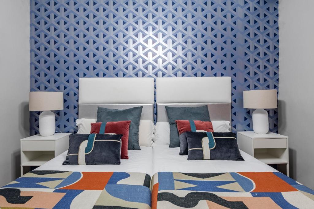 1 dormitorio con 1 cama con pared azul en Beautiful Room in Heart of Madrid, en Madrid