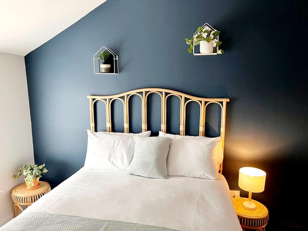 a blue bedroom with a bed with white pillows at 'Bridgewater' at stayBOOM in Morecambe